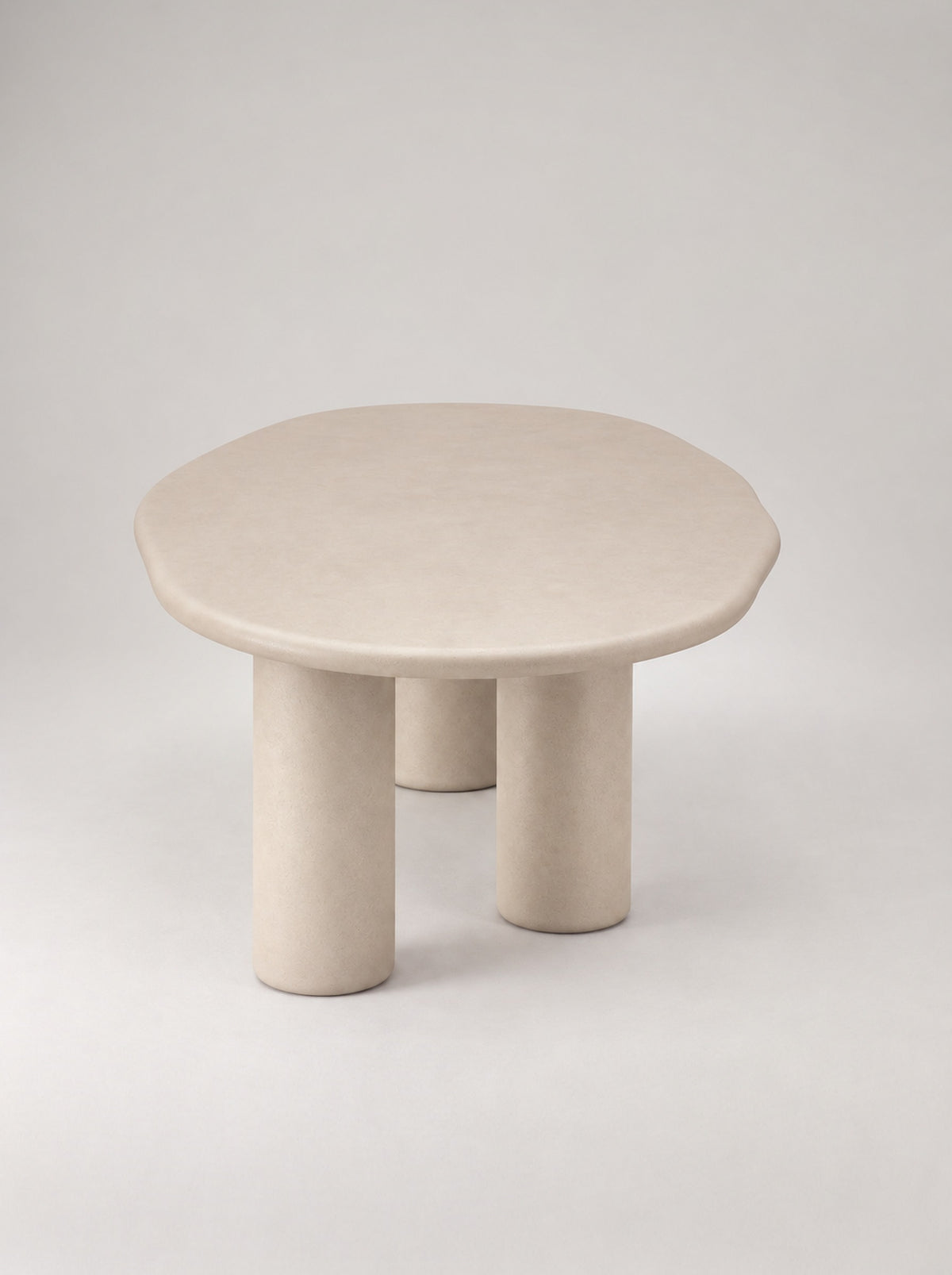 Steen eettafel van de zijkant, ovaal beton ciré blad op drie ronde poten