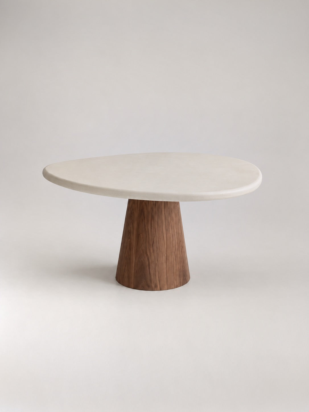 Organisch ronde eettafel in beton ciré met walnoot poot