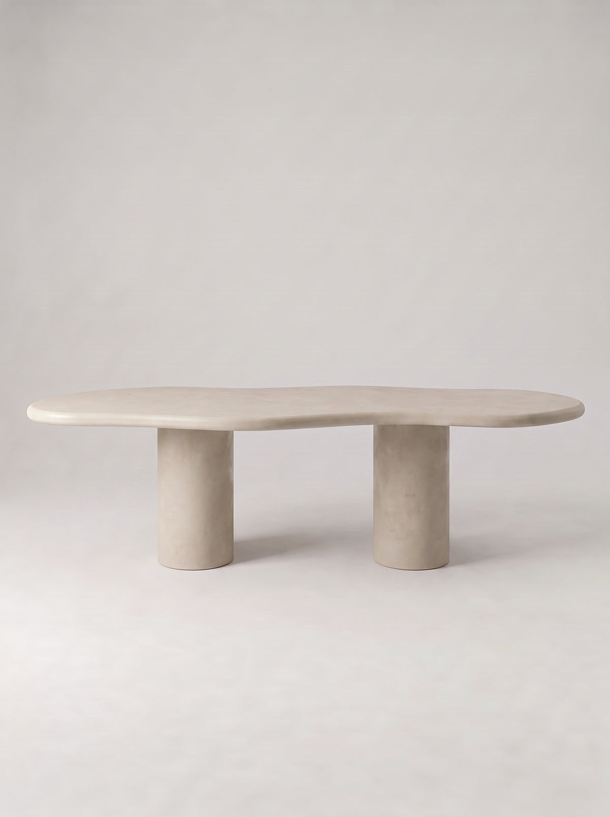 Wolk eettafel met organisch blad in beton ciré op twee ronde poten, vooraanzicht
