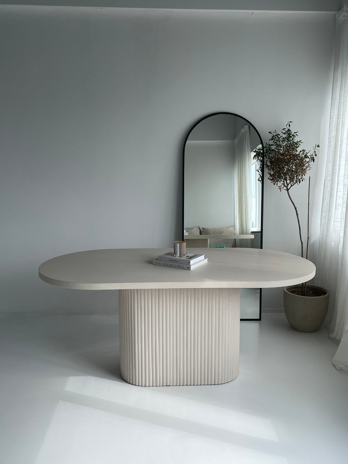 Mokani ovale betoncire eettafel met geribbelde poot.