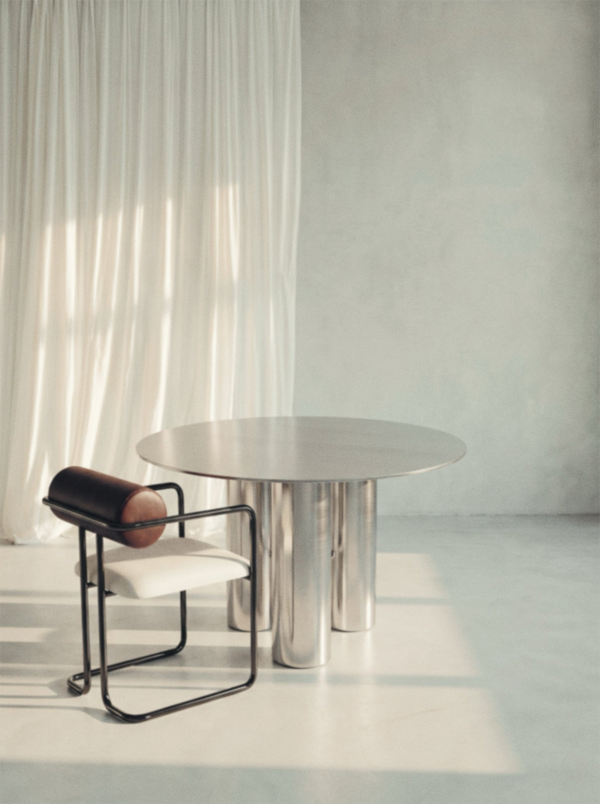 Spiegel eettafel met stoel in een licht interieur met linnen gordijnen
