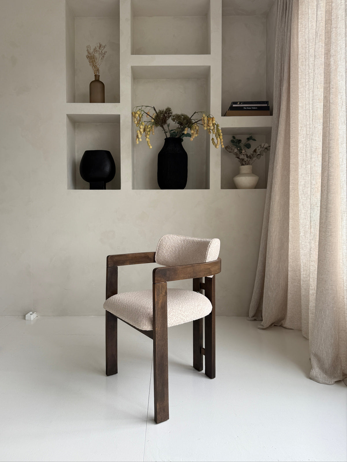 Mokani stijlvolle designstoel met zachte bouclé stof en warme walnoot houten poten