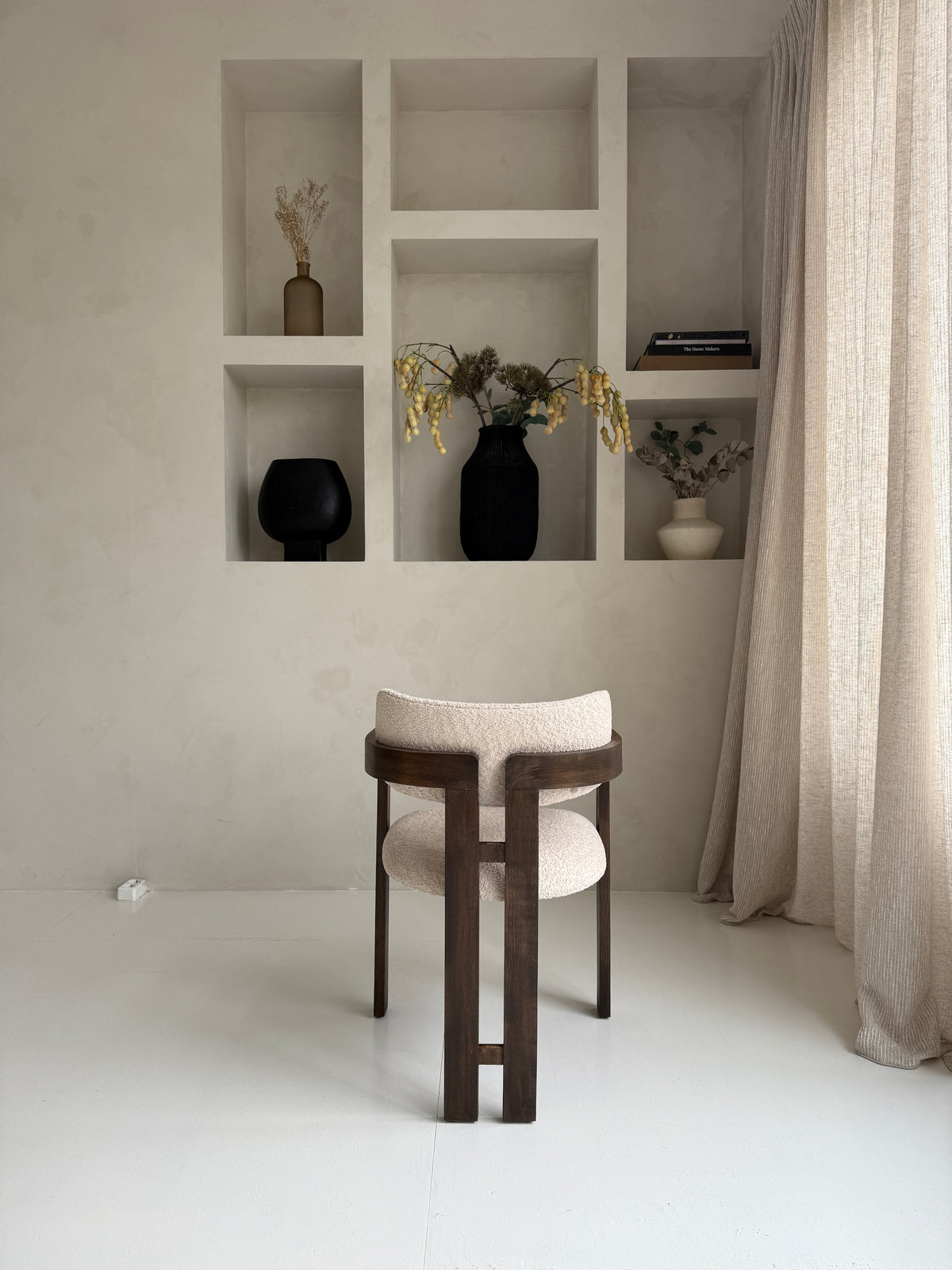 Mokani stijlvolle designstoel met zachte bouclé stof en warme walnoot houten poten