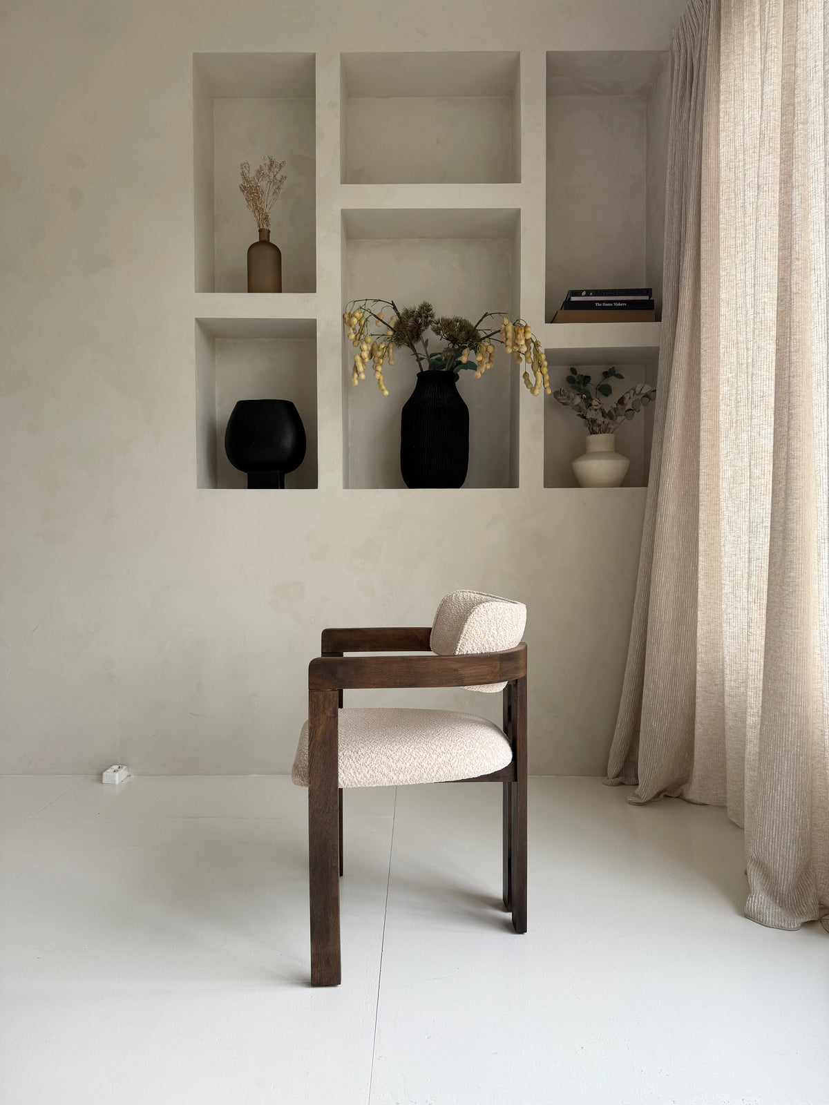 Mokani stijlvolle designstoel met zachte bouclé stof en warme walnoot houten poten