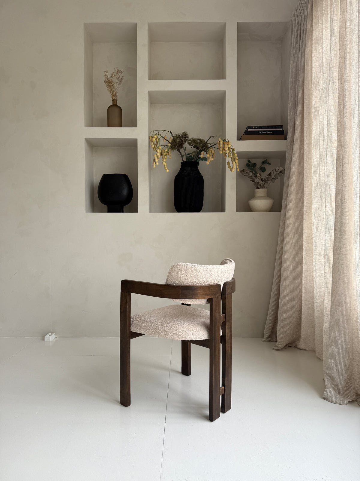 Mokani stijlvolle designstoel met zachte bouclé stof en warme walnoot houten poten