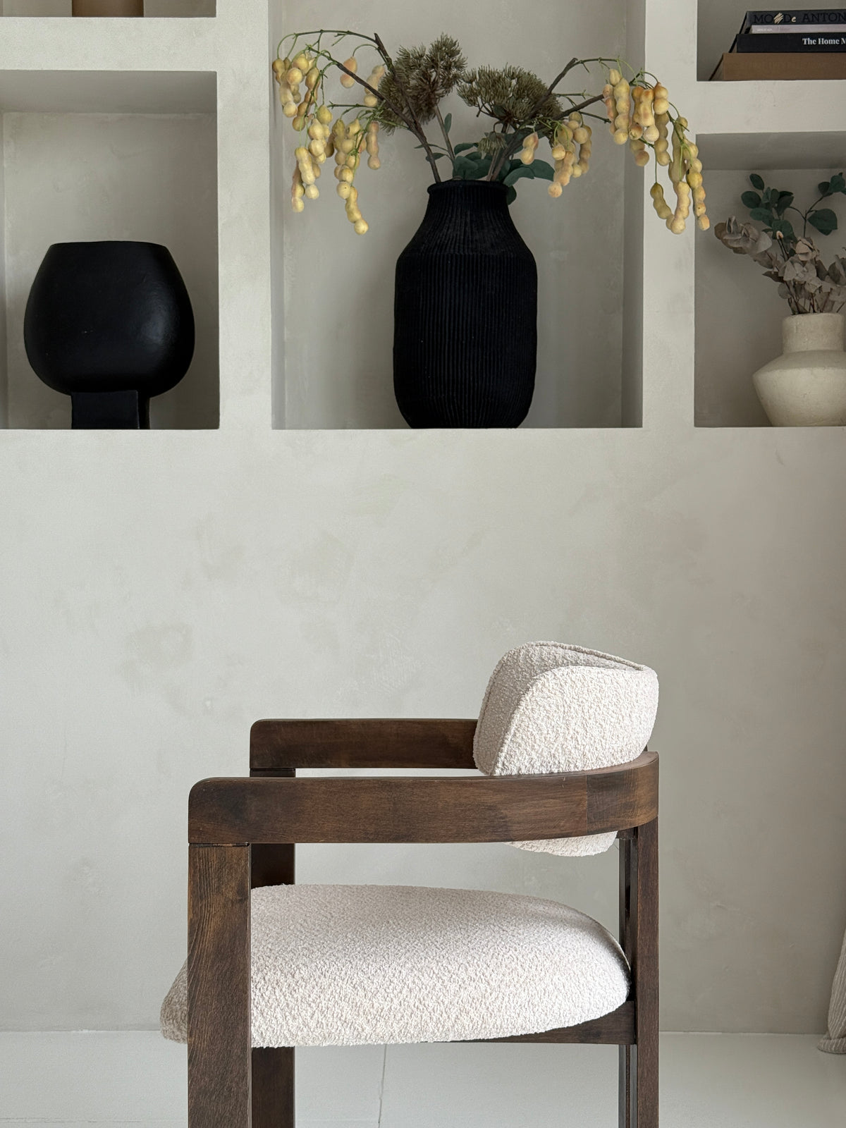 Mokani stijlvolle designstoel met zachte bouclé stof en warme walnoot houten poten