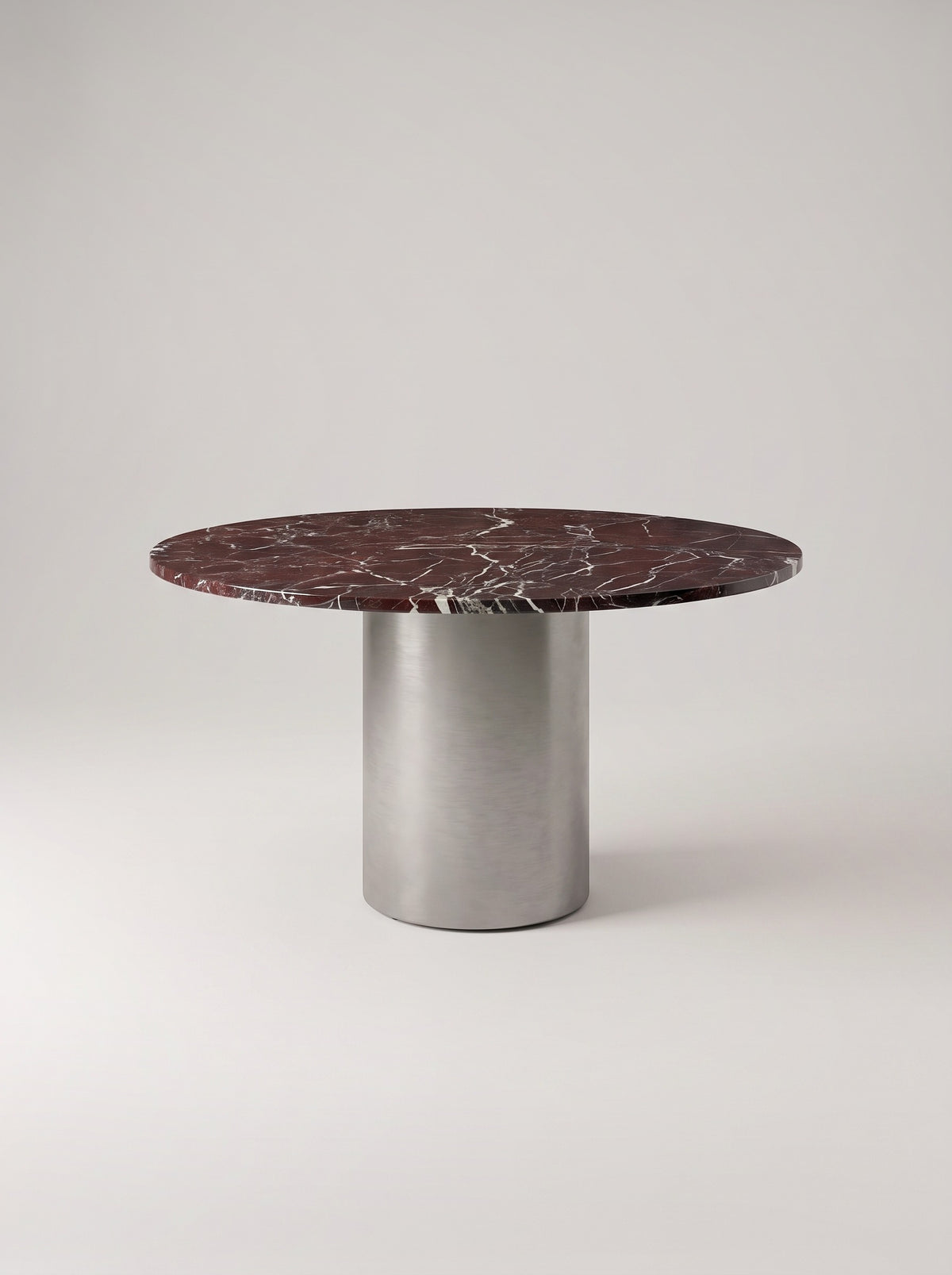 Rosso eettafel met rond blad in rode marmerlook op RVS middenvoet, vooraanzicht