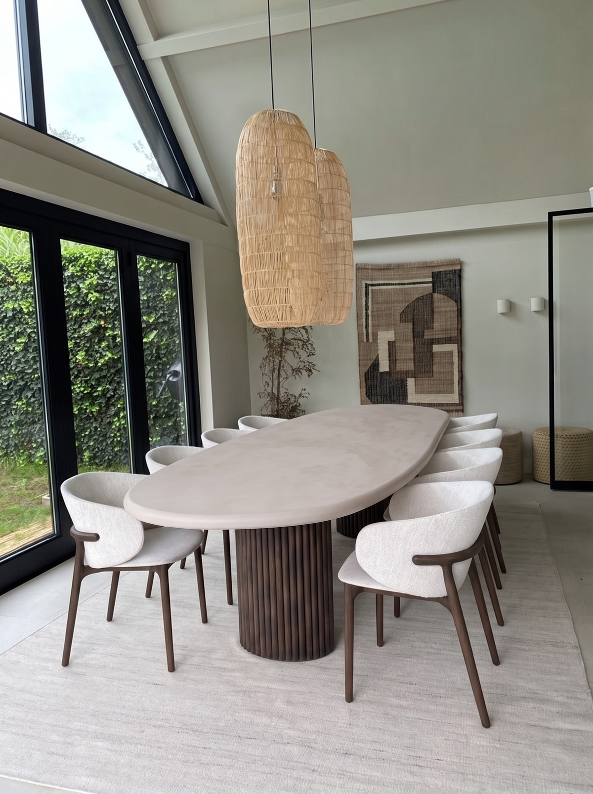 Kiezel eettafel in een lichte eetkamer met rieten hanglampen