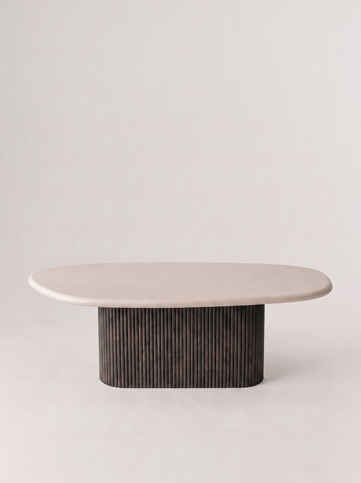 Kiezel eettafel in beton ciré op geribde middenpoot, studiofoto