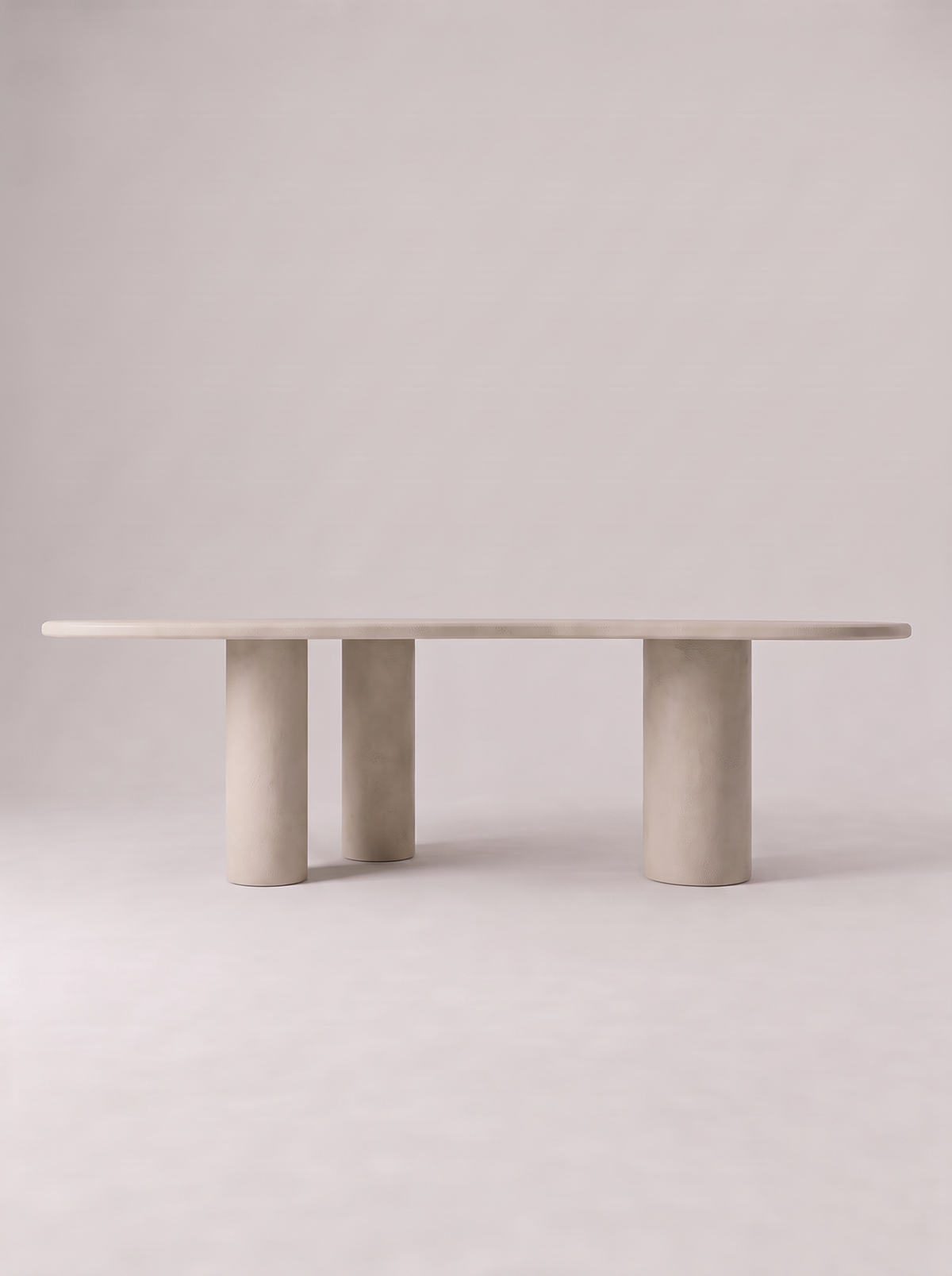 Blad eettafel in beton ciré met organisch bladvormig blad op drie ronde poten